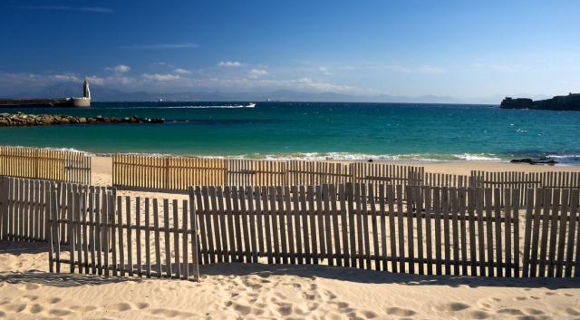playa de tarifa con una valla de madera en la arena